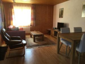 sala de estar con sofá, mesa y TV en Haus Wiedersehn en Blitzingen