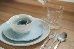 a white bowl on a plate on a table with a fork at Tiny Beach House Zandvoort in Zandvoort