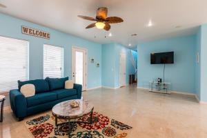 sala de estar con paredes azules y sofá azul en Blue Dolphin en South Padre Island