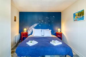 ein Schlafzimmer mit einem blauen Bett und zwei Nachttischen in der Unterkunft Chipote by Carl-Emilie in Épinal