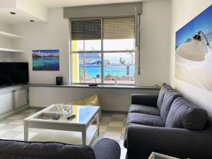 sala de estar con sofá y mesa en Duplex con vistas en primera linea de playa, en Puerto del Rosario