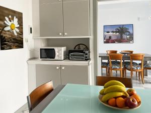 una cocina con mesa y un bol de fruta en Duplex con vistas en primera linea de playa, en Puerto del Rosario