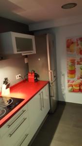eine Küche mit einer roten Arbeitsplatte und einem Kühlschrank in der Unterkunft Moderno apartamento en el parque de cabecera in Valencia