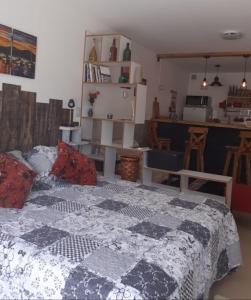 1 dormitorio con 1 cama con edredón en El Escaramujo en San Carlos de Bariloche