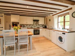 a kitchen with a table and chairs and a sink at Owl's Nest in South Molton