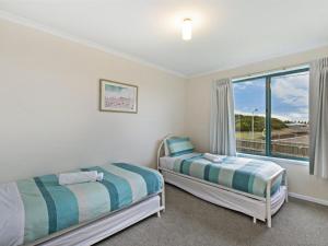 1 dormitorio con 2 camas y ventana en Matilda 2 Crowe Street, en Port Fairy