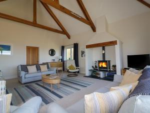 a living room with a couch and a fireplace at Lower Mellan Barn in Coverack