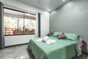 una camera da letto con un letto e asciugamani di Hotel Hoja de Oro Corcovado a Puerto Jiménez
