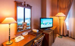 um quarto de hotel com televisão e espelho em A-BRAND HOTEL em Yoichi
