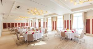 a banquet hall with white tables and chairs and windows at A-BRAND HOTEL in Yoichi