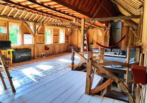 a large room with wooden floors and a wooden ceiling at The Rabbit Tree Hostel in Gili Meno
