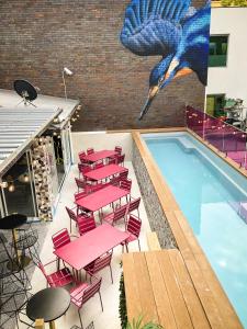 un patio avec des tables et des chaises roses à côté d'une piscine dans l'établissement Brisbane Quarters, à Brisbane