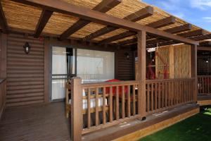a wooden deck with a pergola on a house at Noam Suites in Bruchim Qela' Alon