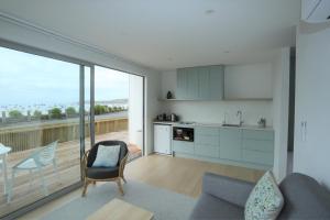 a kitchen and living room with a view of a balcony at Seascape Accommodation in Kaka Point