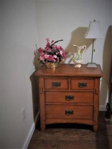 a wooden dresser with a bowl of flowers on it at Cheap East Knoxville Basement Studio in Knoxville