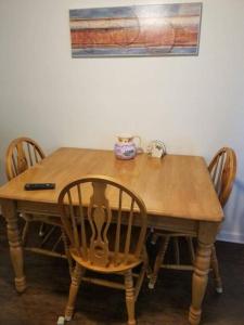 a wooden table with four chairs and a vase on it at Cheap East Knoxville Basement Studio in Knoxville