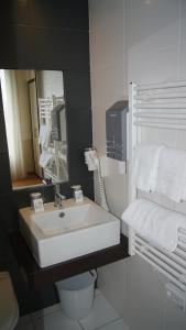 La salle de bains est pourvue d'un lavabo, de toilettes et d'un miroir. dans l'établissement Hotel De La Rade, à Brest