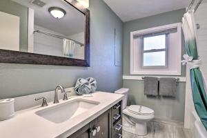 a bathroom with a sink and a toilet and a mirror at Steps to Daytona Beach Updated Home with Deck! in Daytona Beach +19 photos