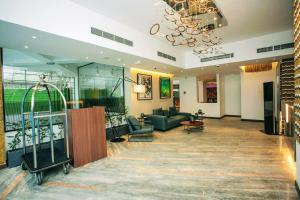 a lobby with a couch and chairs and a chandelier at Hotel Omni Residency Dhaka in Dhaka