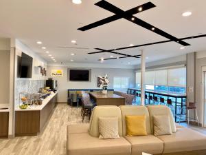 a living room with a couch and a kitchen at Days Inn by Wyndham Beaumont West I-10 Walden in Beaumont