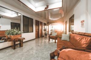 a lobby with couches and chairs in a building at Hotel Hoja de Oro Corcovado in Puerto Jiménez