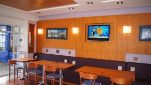 a restaurant with wooden walls and wooden tables and chairs at Hotel De La Rade in Brest