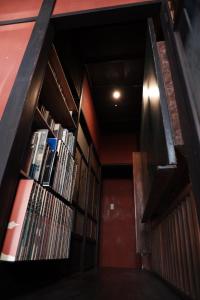 a room with a row of bookshelves in a library at 一棟貸ゲストハウス 傾㐂屋 Kabukiya in Hiroshima