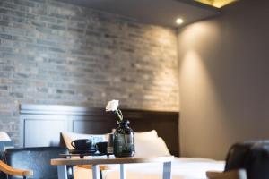 a table with a vase with a flower on it at Boutique Hotel XYM Pyeongtaek in Pyeongtaek