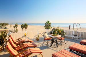 a patio with chairs and a table and the beach at Venice Suites in Los Angeles