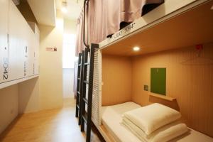 a bedroom with a bed and a window at Loosha Hostel in Taichung