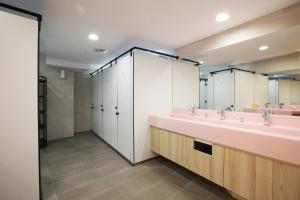 a bathroom with a sink and a mirror at Loosha Hostel in Taichung