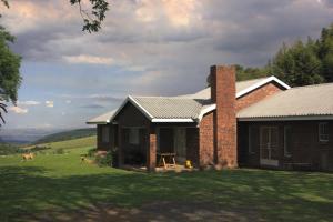 a brick house in a field with a grass yard at The Old Mushroom Farm in Howick