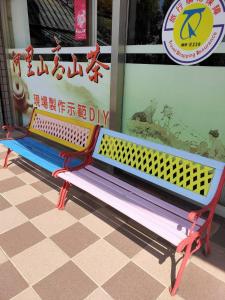 un banco colorido sentado frente a una tienda en 悟 佐茶 Satori tea, en Leye