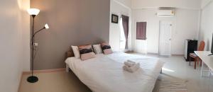 1 dormitorio con 1 cama con sábanas y almohadas blancas en Prinya house ปริญญา เฮ้าส์, en Ban Huai Kapi