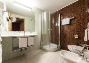 a bathroom with a sink, toilet and shower at Hotel Antares in Selva di Val Gardena