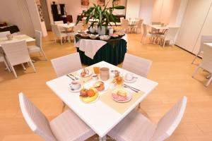 un tavolo bianco con piatti di cibo sopra di Standard Hotel Udine a Pradamano