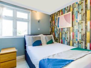 1 dormitorio con 1 cama y una pared colorida en Sino Hotel, en Londres