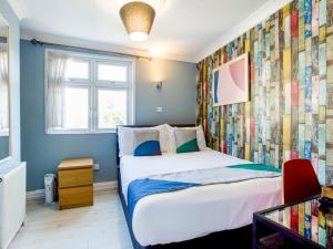 a bedroom with a bed and a colorful wall at Sino Hotel in London
