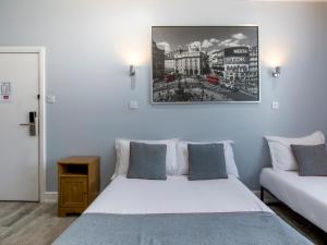 - une chambre avec 2 lits et une photo sur le mur dans l'établissement Sino Hotel, à Londres