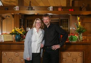 un hombre y una mujer de pie en una cocina en Studtmann's Gasthof, en Egestorf