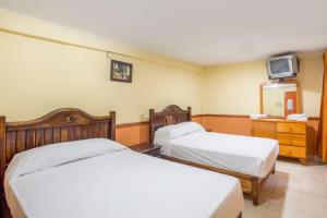 um quarto de hotel com duas camas e uma televisão em OYO Hotel San Agustin em Acambay