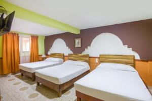 Zimmer mit 3 Betten und einem Flachbild-TV in der Unterkunft OYO Hotel San Agustin in Acambay