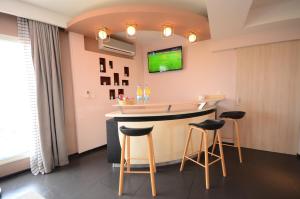 a bar in a room with stools and a tv at Hotel La Villette in Antananarivo