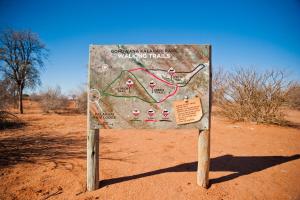 a sign in the middle of a dirt field at Kalahari Anib Campsite in Hardap