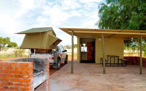 unter einem Schuppen mit einem Zelt geparkt in der Unterkunft Kalahari Anib Campsite in Hardap