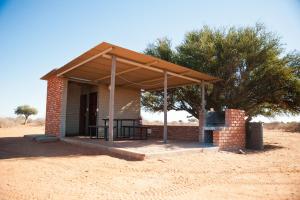a brick building with a grill in the desert at Kalahari Anib Campsite in Hardap