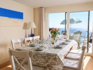 a dining room table with a view of the ocean at Courtenay Villa in Salcombe