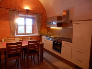 cocina con mesa, sillas y ventana en anno Tyrol en Biberwier
