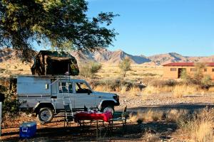ein LKW, der mitten auf einem Feld parkt in der Unterkunft Namib Desert Campsite in Solitaire