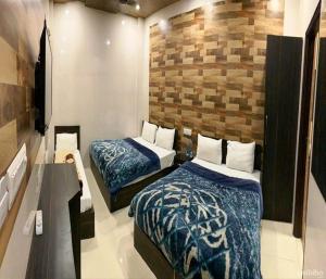 a bedroom with two beds and a brick wall at Hotel Star Light in Amritsar